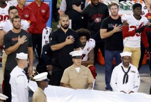 Colin Kaepernick takes a knee during the national anthem.